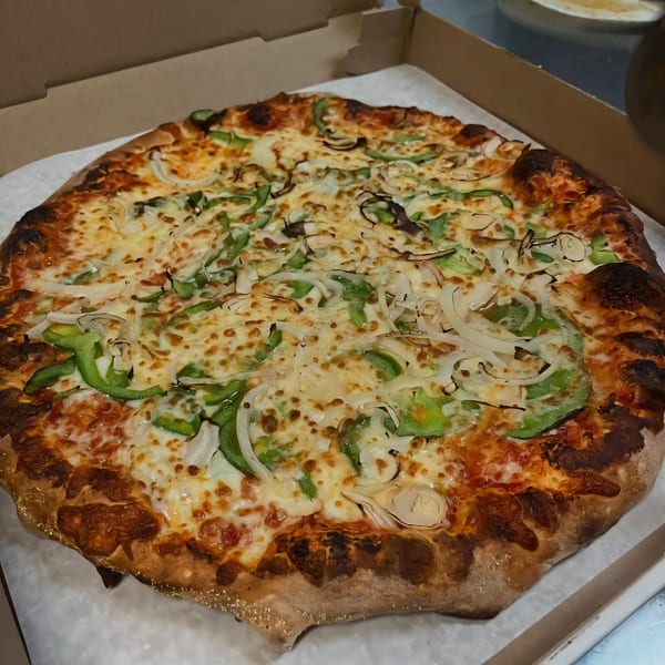 South St Pizzeria's whole pizza with green peppers, onions, and melted cheese in a box.